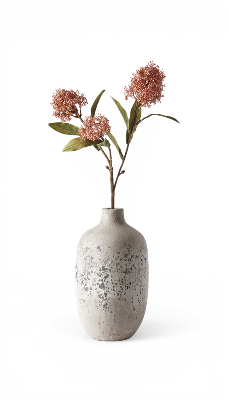 Grå, spættet keramikvase med to stilke med rosa klasblomster og grønne blade.