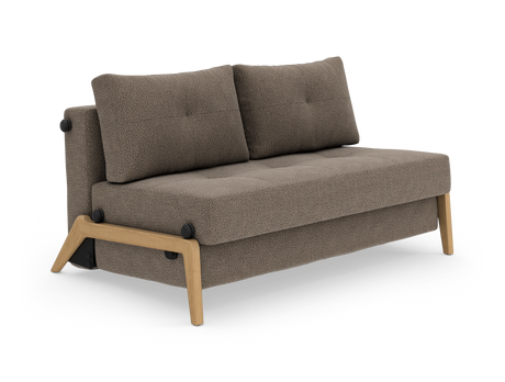 Kompakt 2-personers sofa i beige/brun tekstil med træramme og -ben, to ryghynder og tuftet sæde, fotograferet i studie, set skråt forfra.