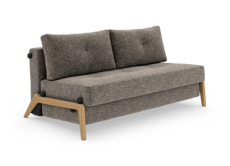Grå sofa med træben og to ryghynder, frilagt på hvid baggrund i vinklet visning.