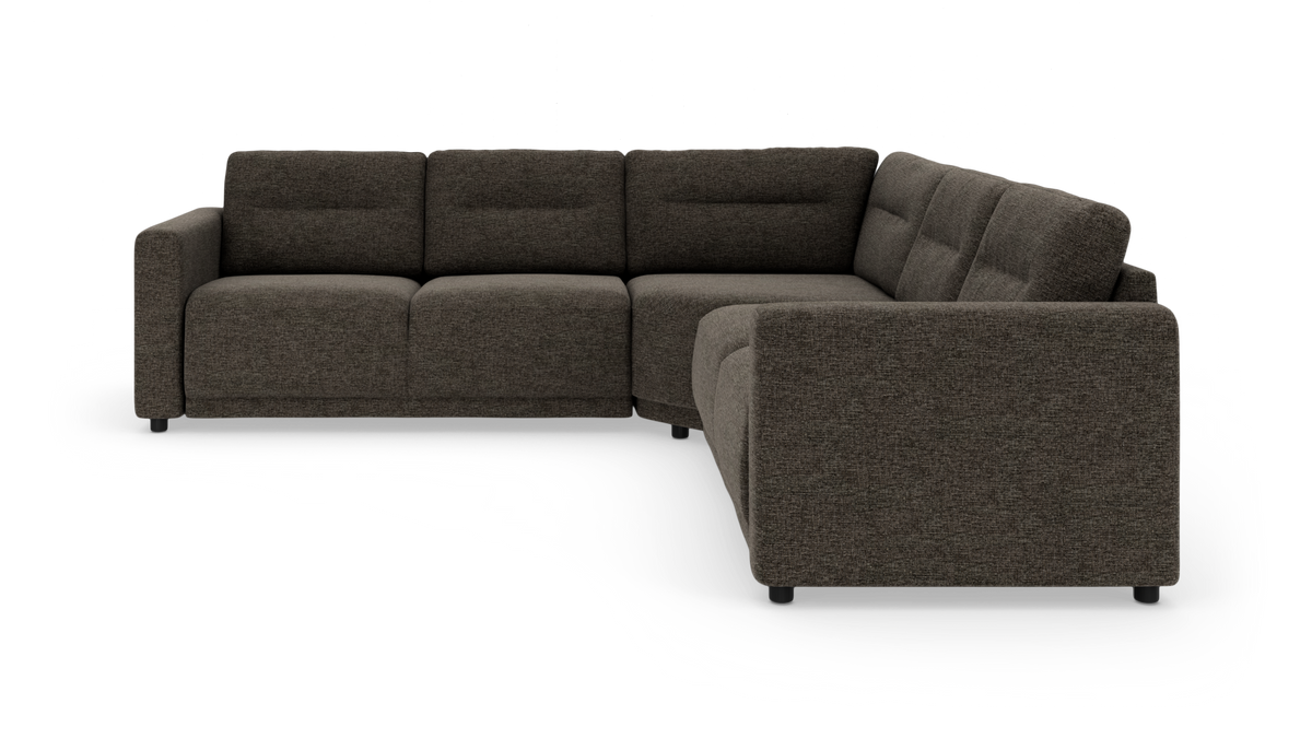 Modulær L‑formet hjørnesofa i mørk grå/brun tekstil med lave sorte ben, vist i studiemiljø.