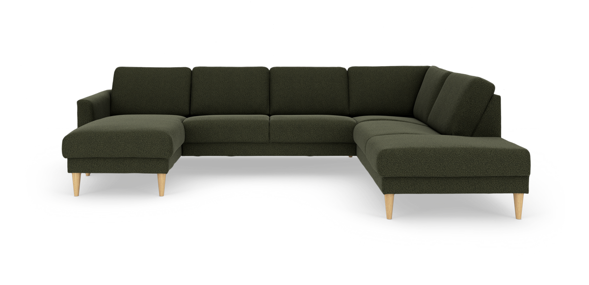 Mørkegrøn hjørnesofa i L‑form med chaiselong til venstre og lyse træben, frilagt på hvid baggrund.