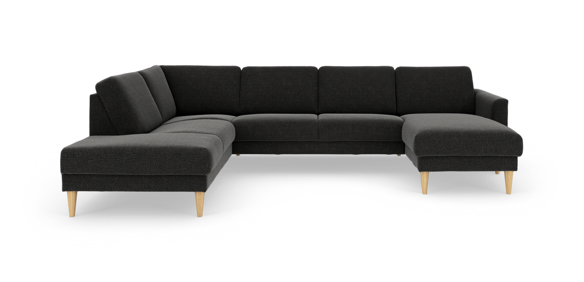 Mørkegrå hjørnesofa i stof med chaiselong til højre og lyse træben.