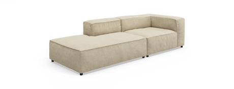 Beige modulsofa med venstre chaiselong og hjørneryg, lav profil og korte sorte ben, fritlagt på hvid baggrund.