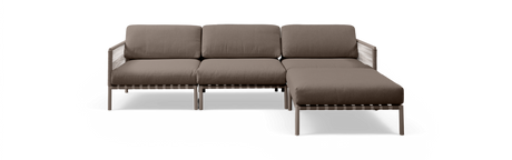 Brun modulsofa med chaiselong til højre, frilagt mod sort baggrund.