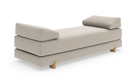 Beige daybed med bløde bolster i begge ender og træben, frilagt på hvid baggrund.