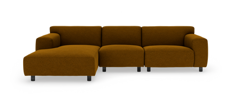 Brun polstret chaiselong/modulsofa med lav ryg og sorte ben, frilagt på hvid baggrund.
