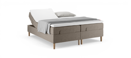 Justerbar dobbeltseng med hævet hovedende, beige polstret base, hvid topmadras samt gråt plaid og pude.