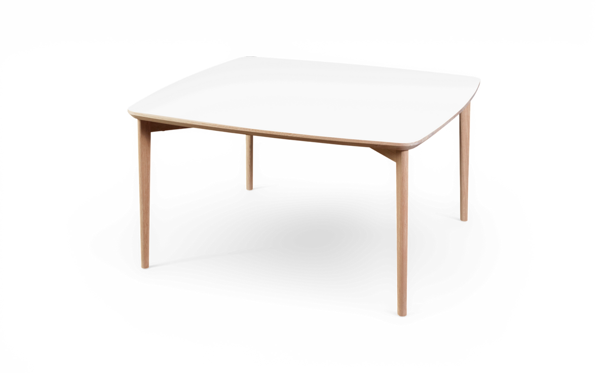 Firkantet spisebord med hvid bordplade og lyse træben, afrundede hjørner, frilagt på hvid baggrund.