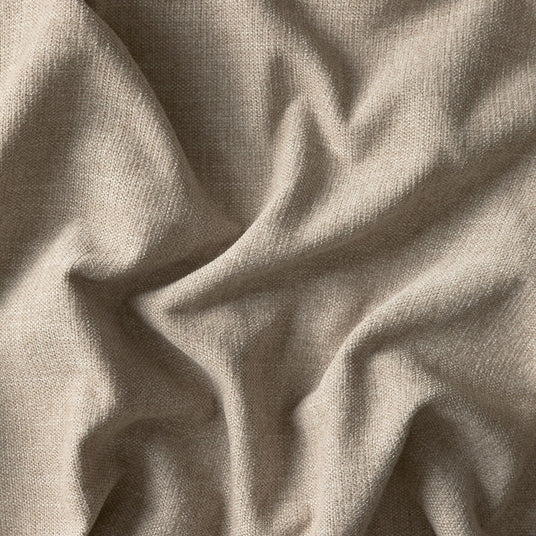 Nærbillede af beige vævet stof med bløde folder og tekstur.