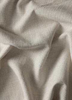 Nærbillede af beige vævet tekstil med bløde folder.