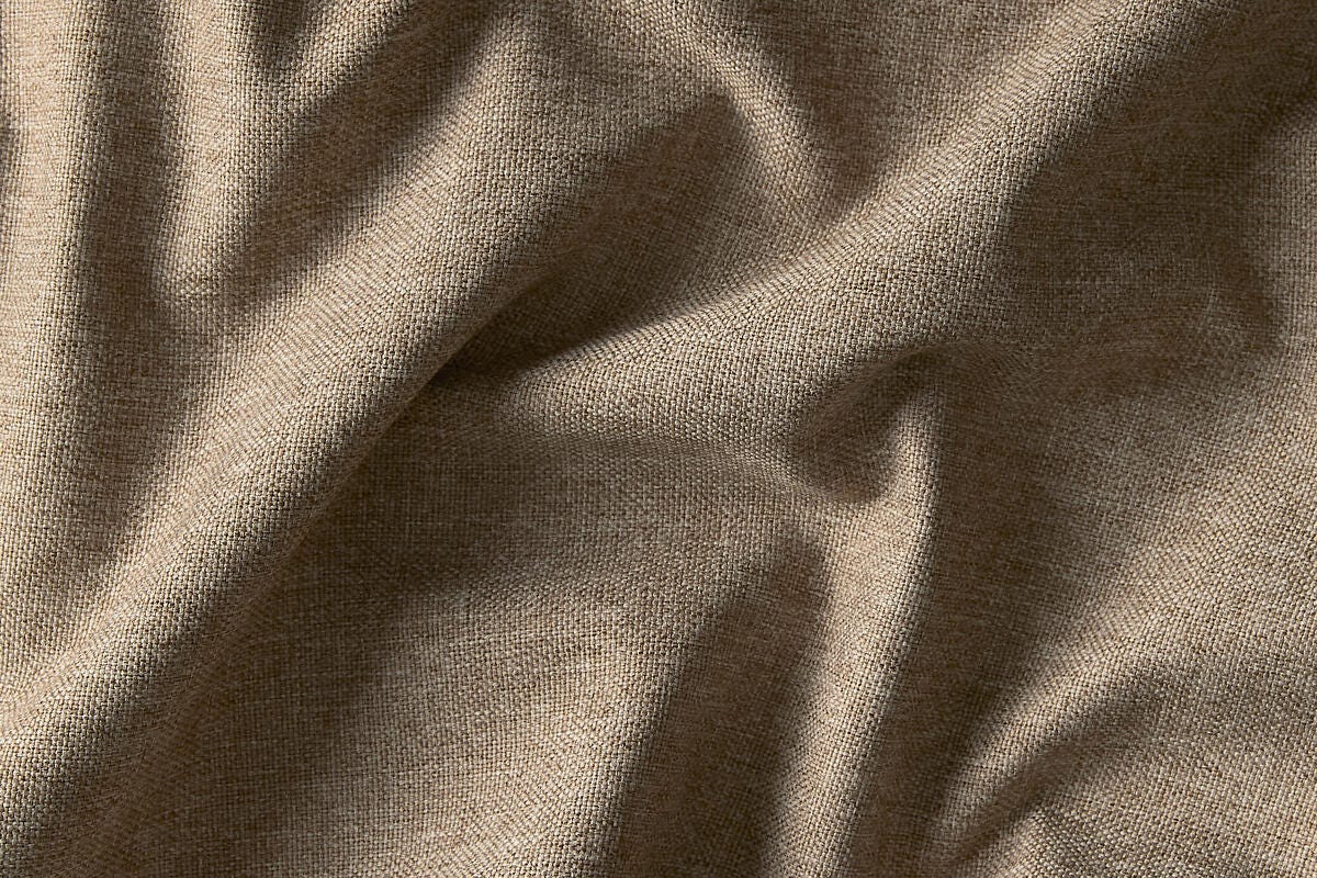 Beige linnedlignende stof i close-up med blød tekstur og naturlige folder.