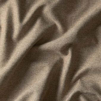 Beige linnedlignende stof i close-up med blød tekstur og naturlige folder.