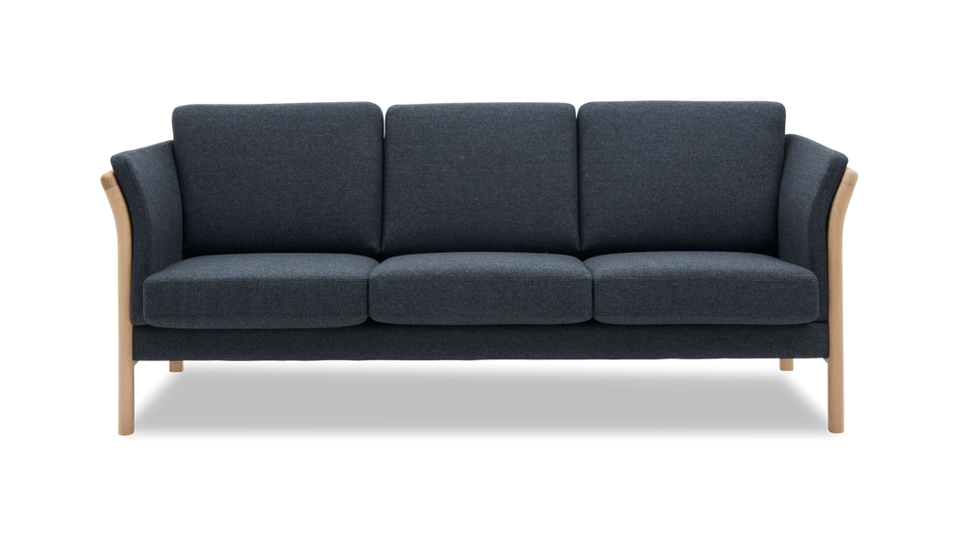 Mørk blå tresæders sofa med lyse træben og afrundede armlæn, frilagt mod hvid baggrund.