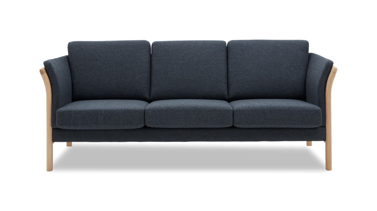 Mørk blå tresæders sofa med lyse træben og afrundede armlæn, frilagt mod hvid baggrund.