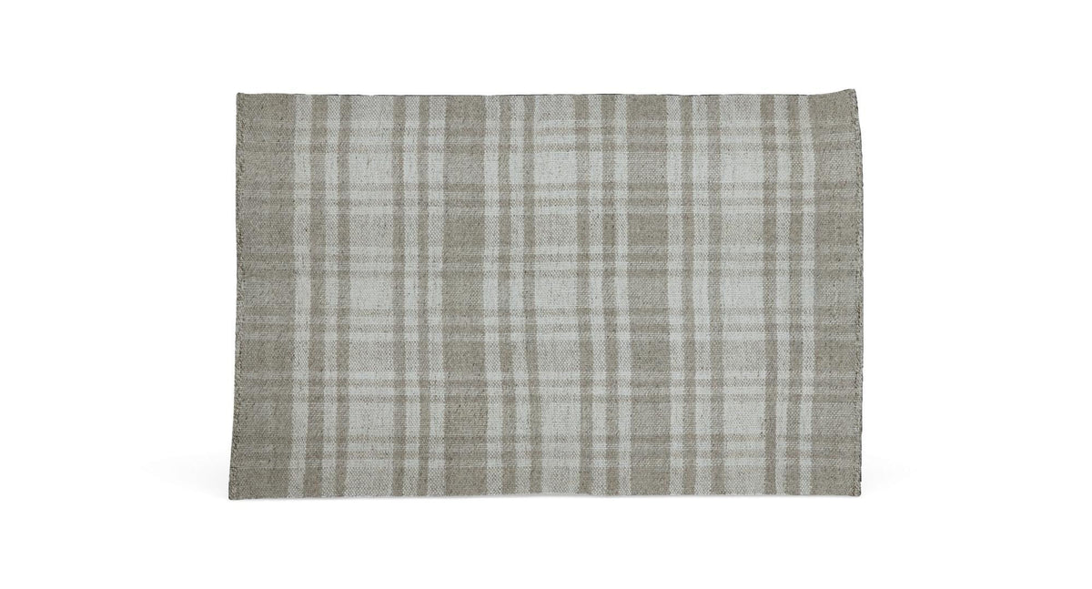 Lyst og moderne stue med beige sofa, grå puf, glas-sofabord med sorte ben, lys og stearinlys, neutral tæppe og hylder med planter og dekoration i dagslys fra store vinduer med lette gardiner.