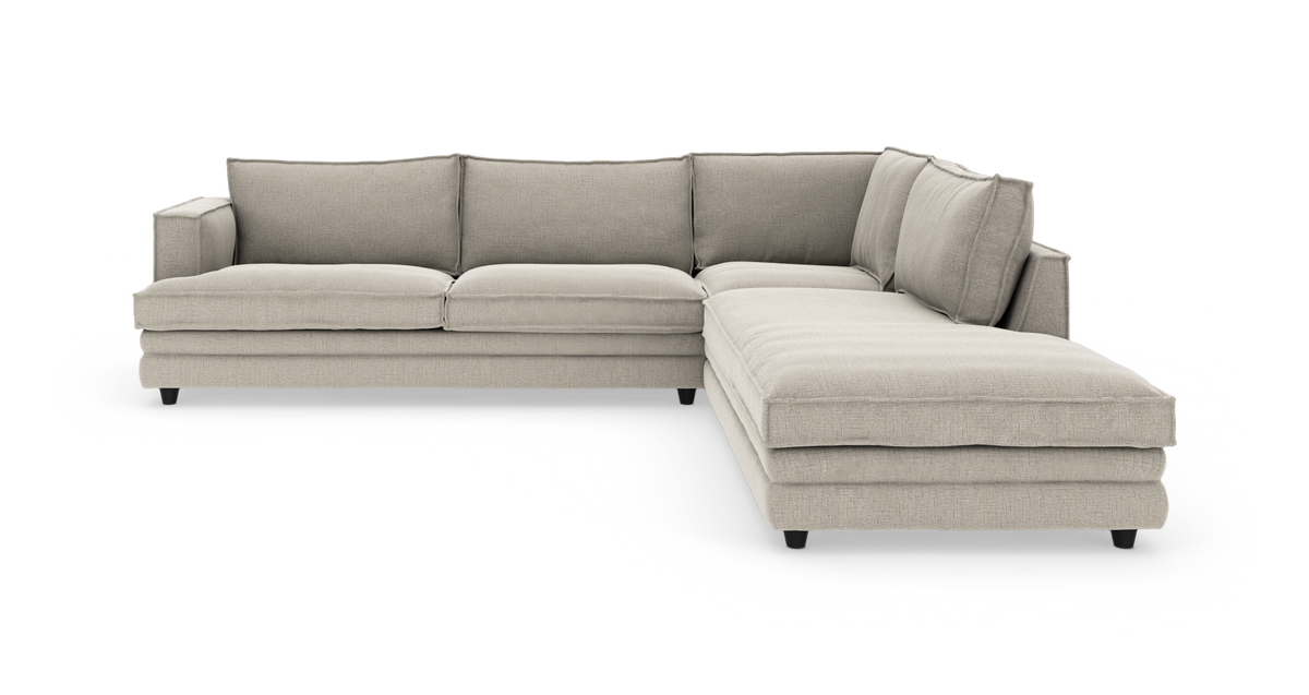L‑formet beige hjørnesofa med chaiselong til højre, frilagt på hvid baggrund.