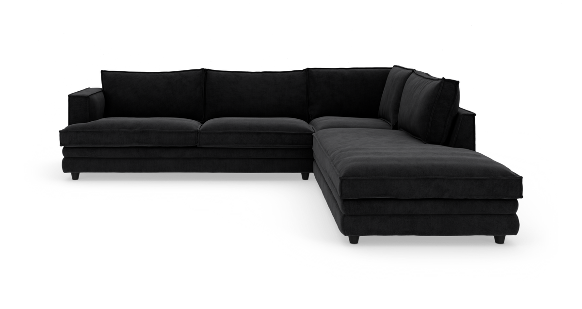 Sort hjørnesofa med chaiselong vist i studie på hvid baggrund.