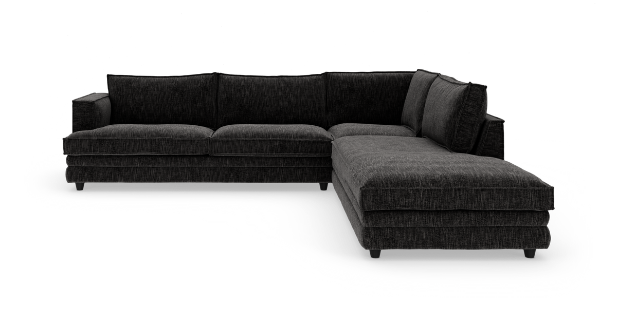 Mørkegrå L-formet modulsofa med chaiselong til højre på hvid baggrund.