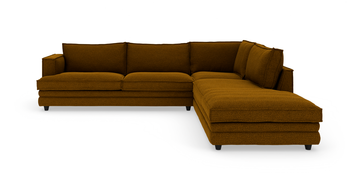 Vinkelmodulsofa i sennepsgul tekstil med chaiselong til højre, frilagt på hvid baggrund.