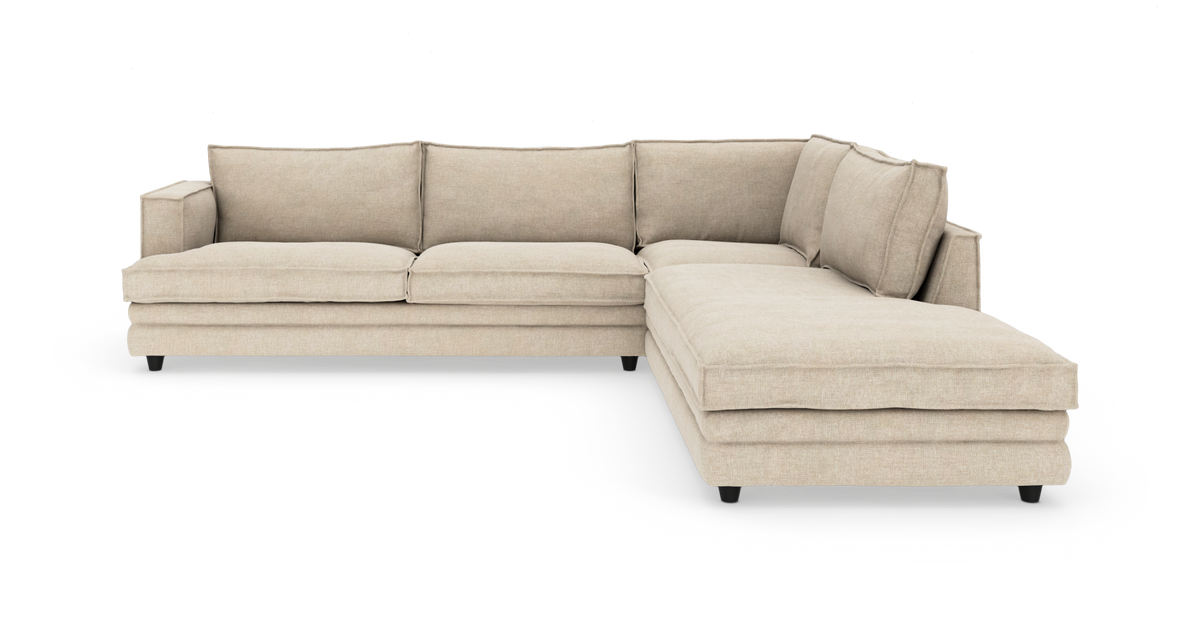 Beige L‑formet hjørnesofa med chaiselong til højre, isoleret på hvid baggrund.
