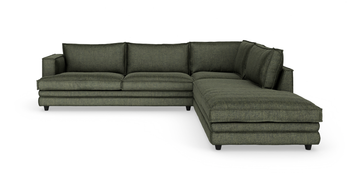 Grøn L-sofa med chaiselong til højre, i studie på hvid baggrund.