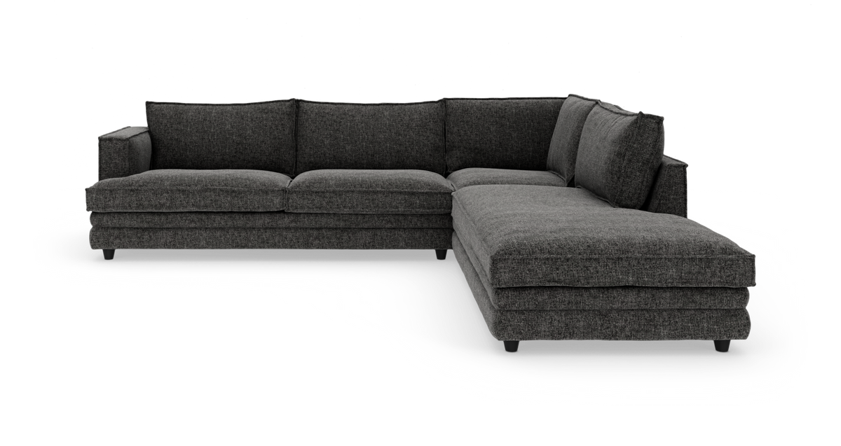 Mørkegrå L-formet hjørnesofa med chaiselong til højre, fritstående mod hvid baggrund.