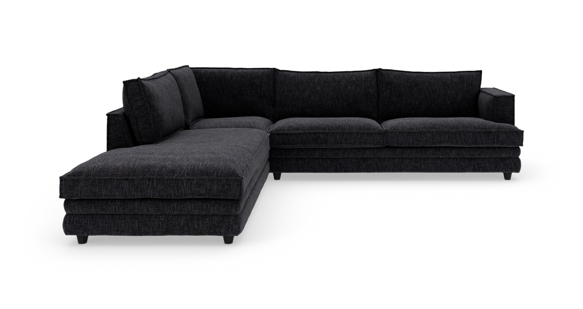Mørkegrå L‑formet hjørnesofa med venstrevendt chaiselong, fotograferet i studie på hvid baggrund.
