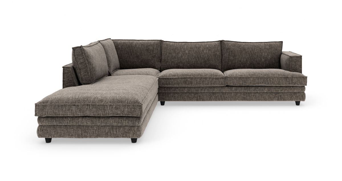 Mørkegrå hjørnesofa med venstrevendt chaiselong, i stof med bløde puder, frilagt på hvid baggrund.