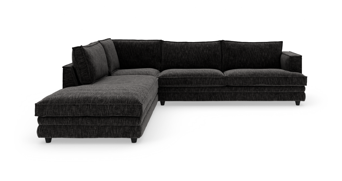 Mørkegrå hjørnesofa med chaiselong, fritlagt på hvid baggrund.