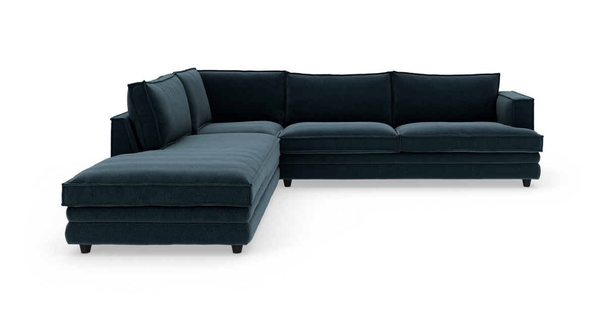 Mørkeblå hjørnesofa med chaiselong til venstre, fritlagt på hvid baggrund.