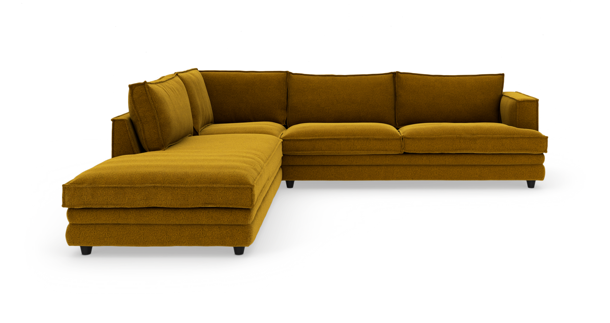Sennepsgul L-sofa med chaiselong til venstre og armlæn til højre, frilagt på hvid baggrund.