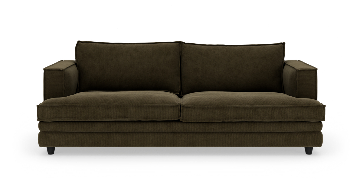 Mørkegrøn sofa i cordfløjl med brede armlæn, set forfra på hvid studiobaggrund.
