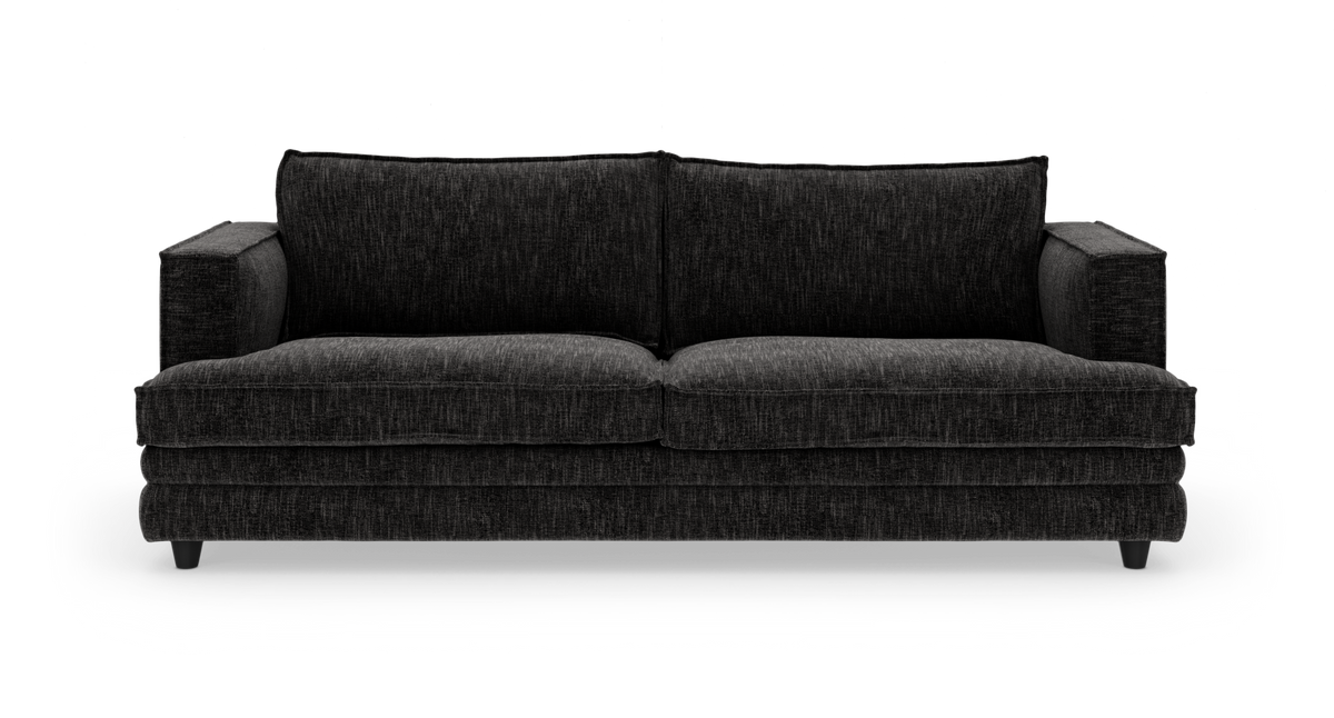 Mørkegrå 3-personers sofa med to store ryghynder, brede armlæn og lave ben, fotograferet forfra mod hvid studiobaggrund.