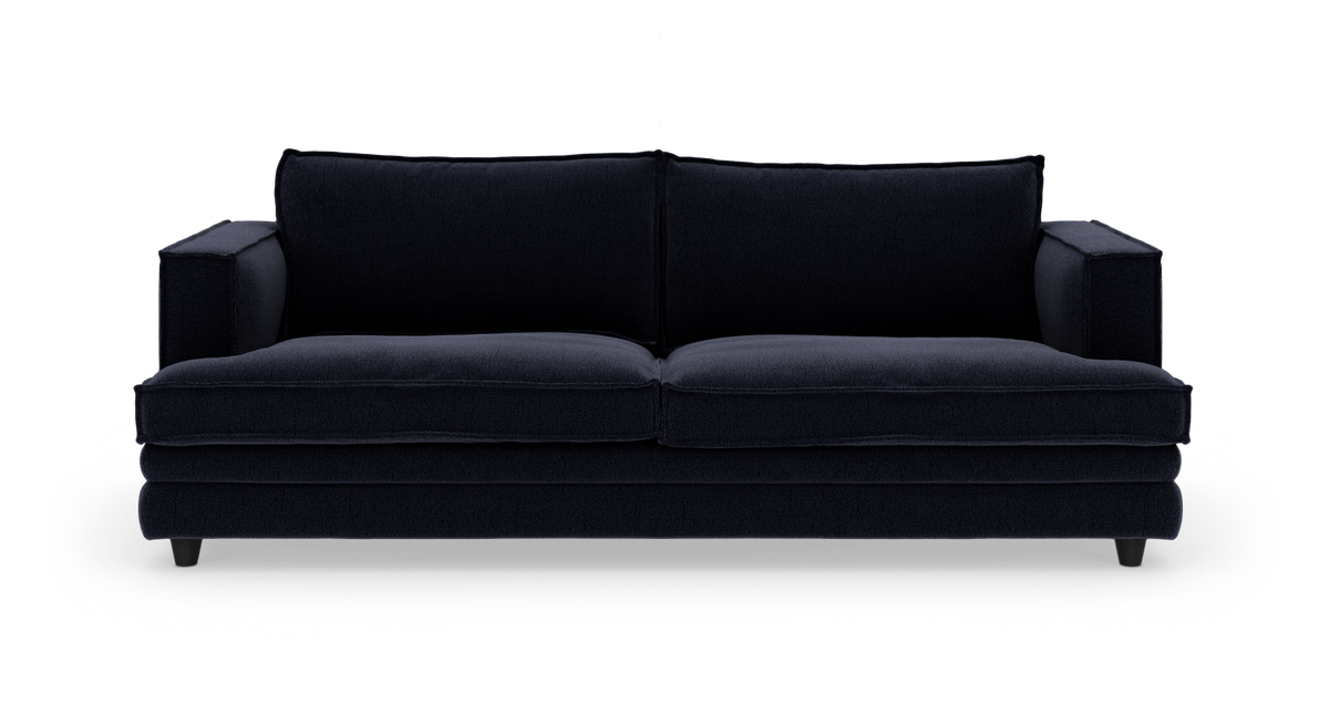 Mørkeblå sofa set forfra på hvid studiebaggrund.
