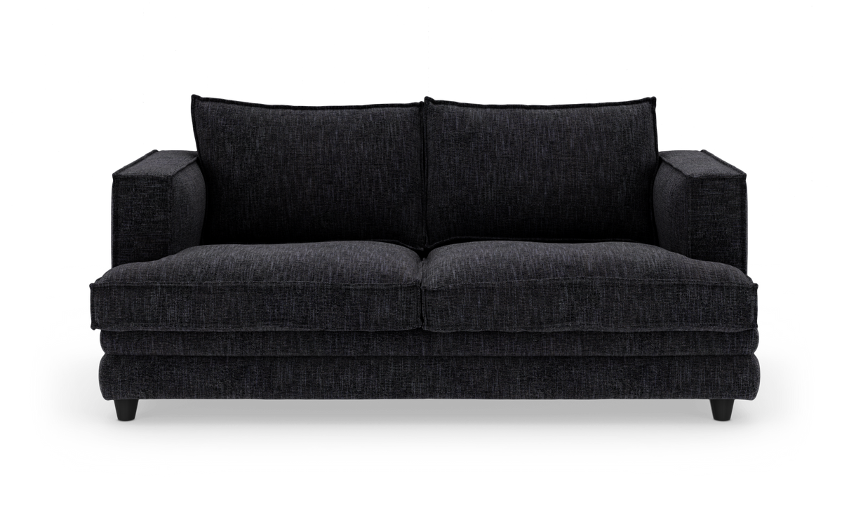 Mørkgrå stofsofa med brede armlæn, fotograferet lige forfra mod hvid baggrund.