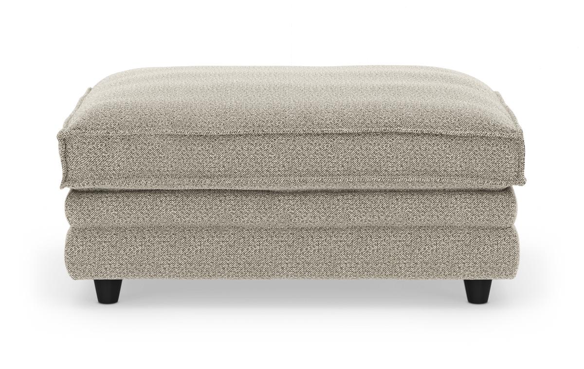 Beige stofpuf/ottoman i studieopsætning set forfra.