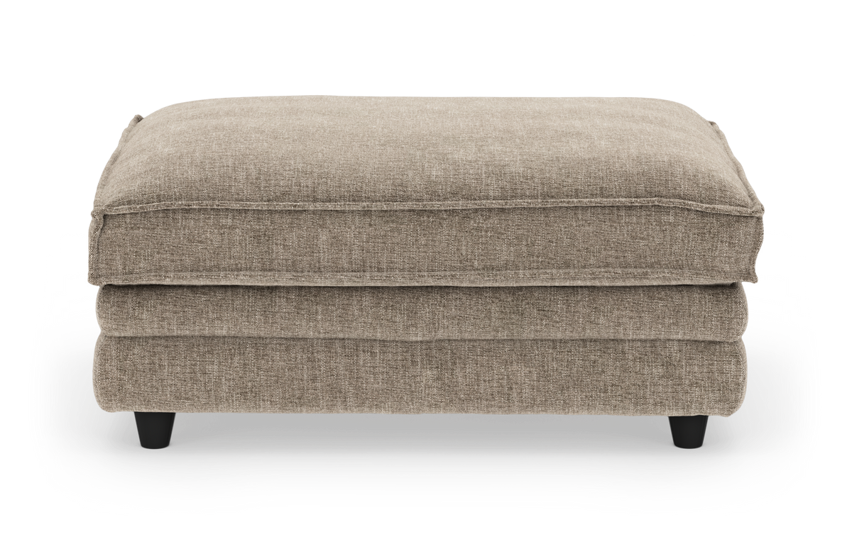 Beige polstret ottoman/puf i stof, frilagt mod hvid baggrund.