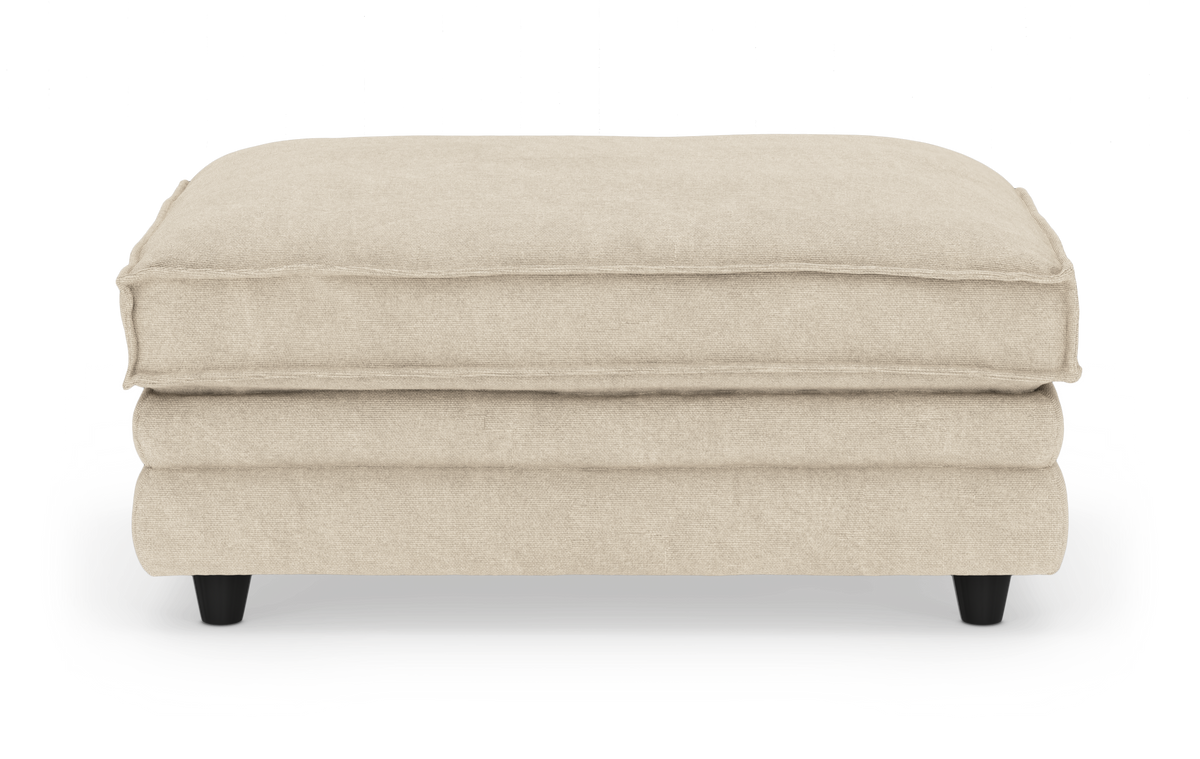 Beige puf/ottoman med blød pudetop, set lige forfra på hvid baggrund.