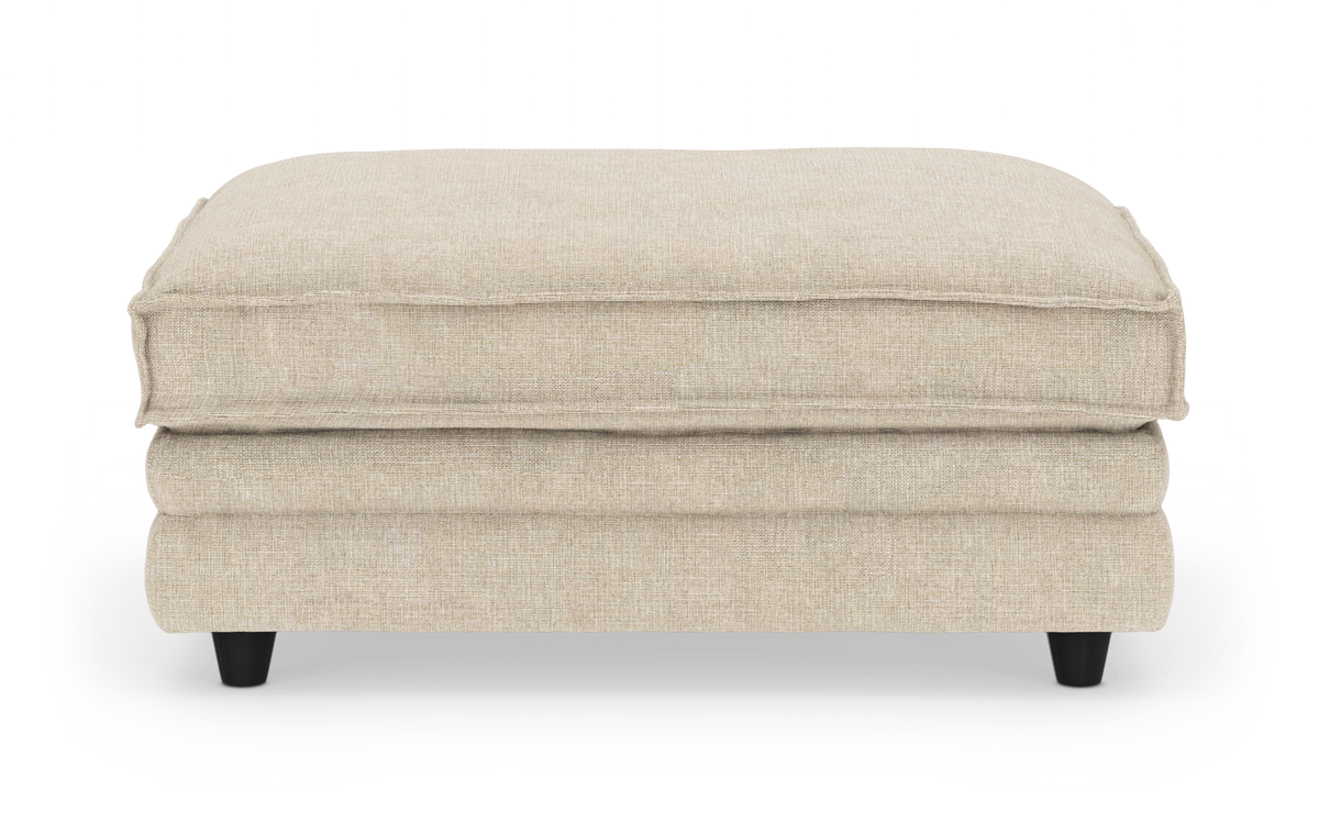 Beige rektangulær stof-ottoman/puf med sorte ben, frilagt på hvid baggrund.