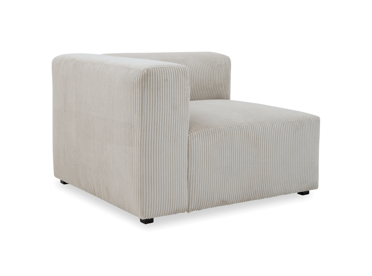 Beige modul-loungestol i bred fløjl med arm og ryg på den ene side, vist skråt forfra.
