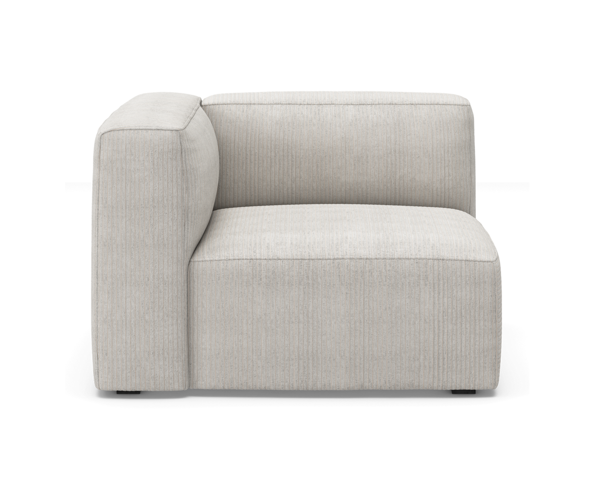 Lys beige modulsofa, hjørnemodul med venstre armlæn i cordfløjl, frilagt på hvid baggrund.