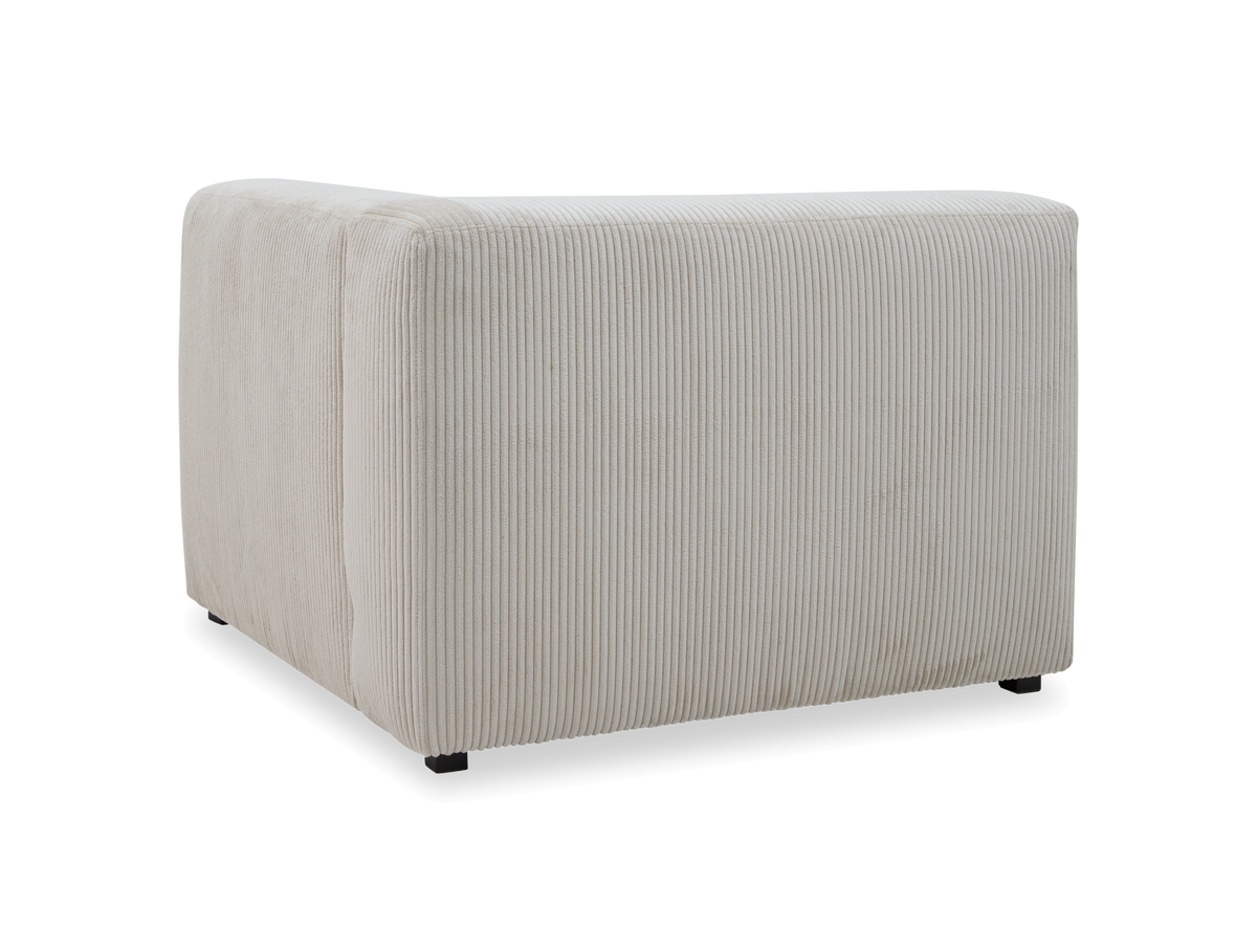 Beige hjørnemodul til sofa i riflet fløjl, set bagfra i vinkel på hvid studiobaggrund.