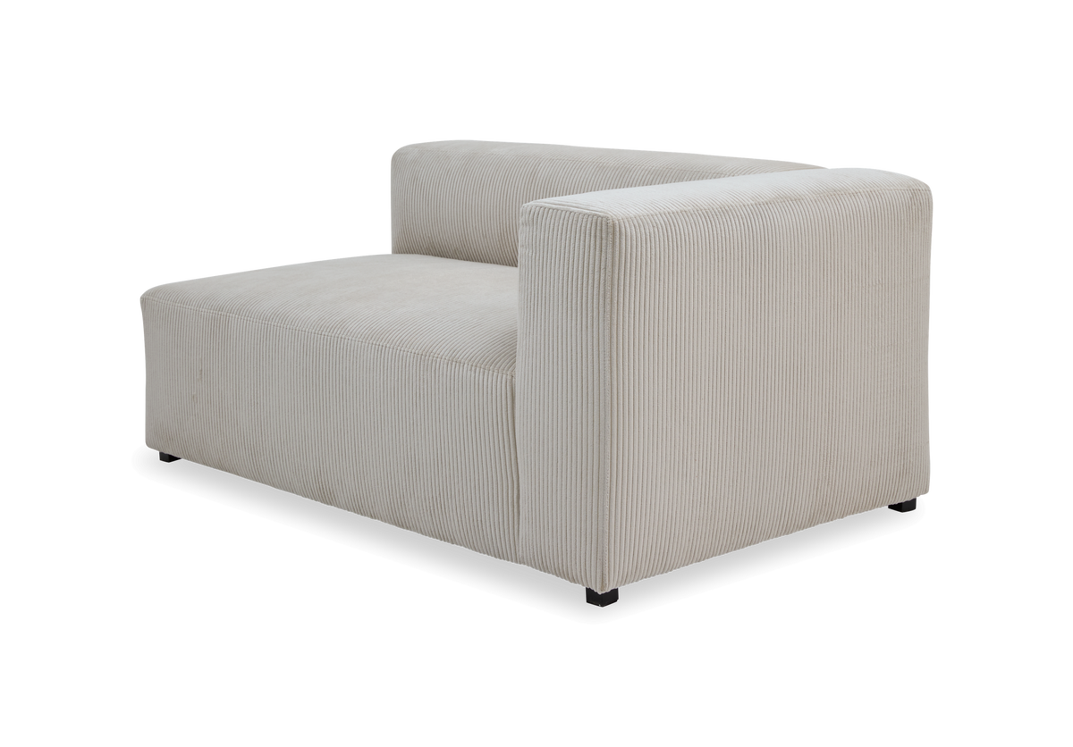 Beige modulsofa med højre armlæn i riflet fløjl, frilagt.