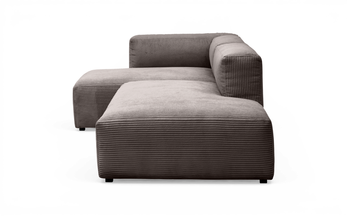 Modulsofa i grå fløjl med højre armlæn og bred chaiselong, fritlagt produktfoto.