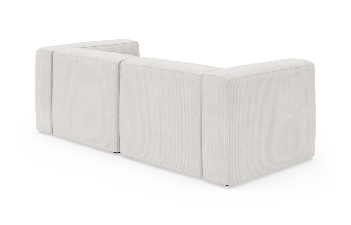 Lys beige modulsofa set bagfra i skrå vinkel mod hvid baggrund.