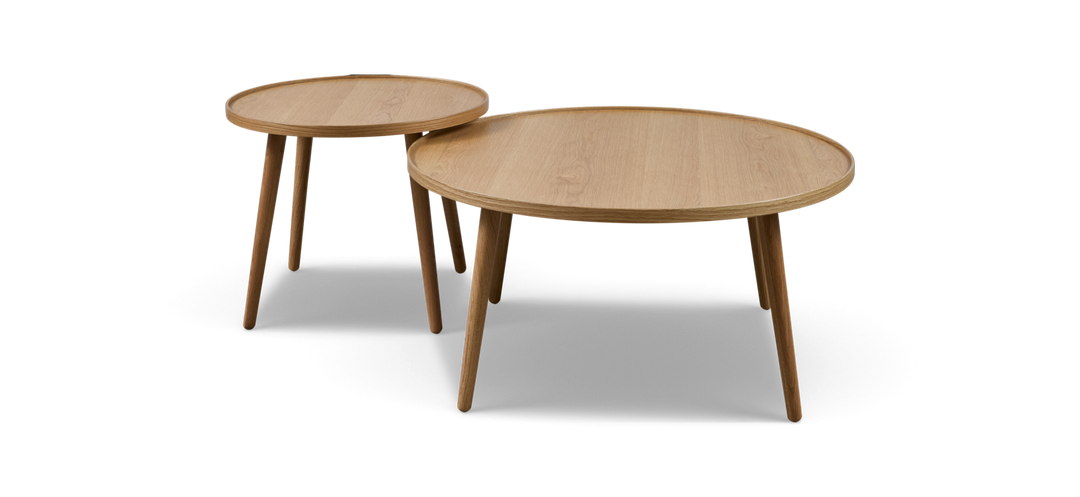 To runde sæt-borde i lys eg med tre ben, fritlagt mod sort baggrund.