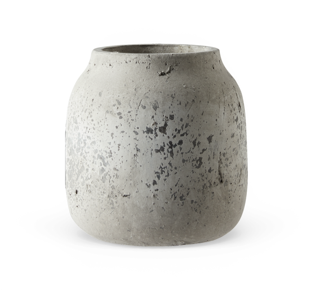 Rå, grå betonvase med rund form og smal åbning.
