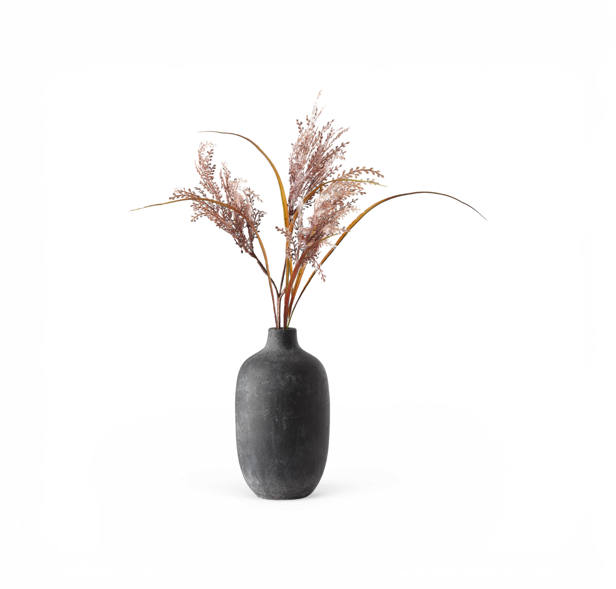 Sort mat vase med rosa tørrede græsstrå, frilagt på hvid baggrund.