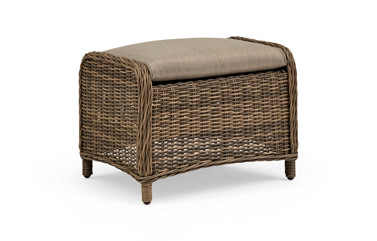 Flettet rattan fodskammel/ottoman med beige hynde på hvid baggrund.