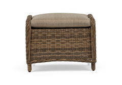 Flettet rattan skammel/ottoman med beige hynde, produktfoto forfra.